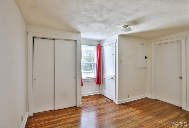1046 Marshall Ave, Saint Louis, MO 63119 - unfurnished bedroom featuring hardwood / wood-style flooring, a textured ceiling, multiple closets, and baseboards