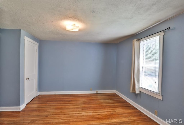 1046 Marshall Ave, Saint Louis, MO 63119 - empty room featuring wood finished floors, plenty of natural light, a textured ceiling, and baseboards