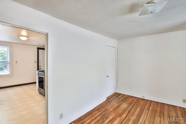 1046 Marshall Ave, Saint Louis, MO 63119 - empty room with baseboards, a textured ceiling, and wood finished floors