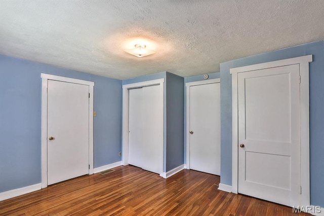 1046 Marshall Ave, Saint Louis, MO 63119 - unfurnished bedroom with wood finished floors, baseboards, a closet, and a textured ceiling