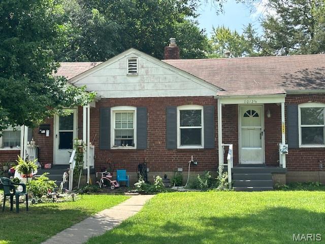 3409 Saint Gregory Ln, Saint Ann, MO 63074 - bungalow-style house featuring a chimney, brick siding, a front yard, and a shingled roof