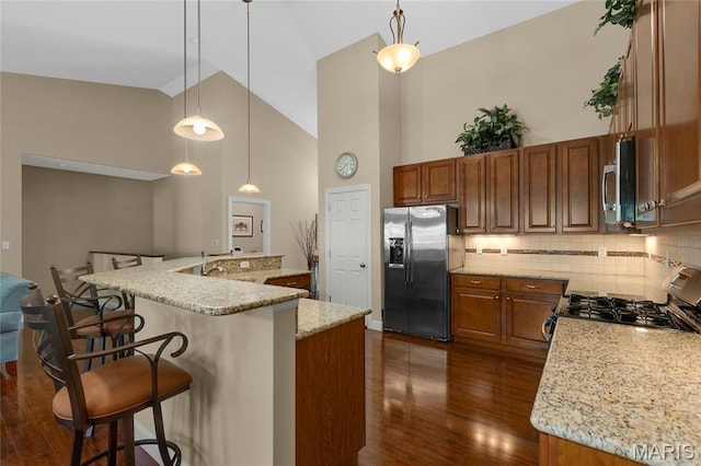 341 Brunhaven Ct, Chesterfield, MO 63017 - kitchen with appliances with stainless steel finishes, high vaulted ceiling, a breakfast bar area, brown cabinets, and dark wood-style flooring