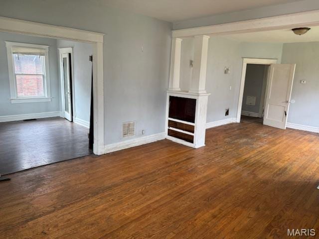 unfurnished living room featuring baseboards and wood finished floors
