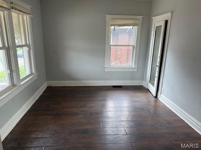 empty room with dark wood-style floors and baseboards