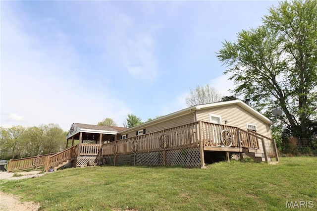 back of house featuring a lawn and a deck