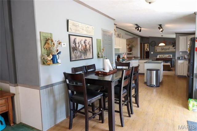 dining space with wainscoting and light wood finished floors
