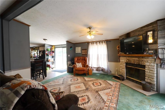 carpeted living area featuring a ceiling fan, a large fireplace, radiator heating unit, and a wainscoted wall