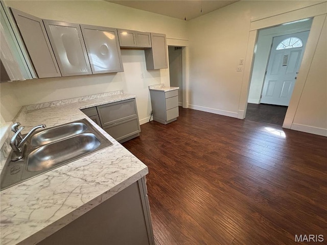 1014 E Broadway, Centralia, IL 62801 - kitchen featuring gray cabinets, a sink, dark wood-style flooring, and baseboards