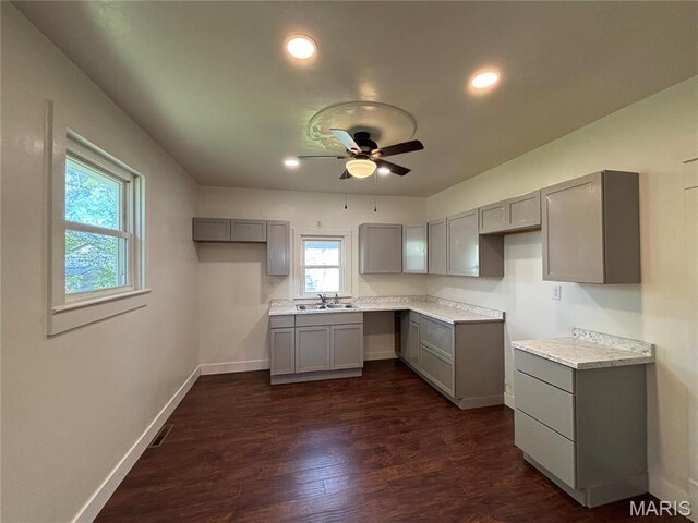 1014 E Broadway, Centralia, IL 62801 - kitchen with gray cabinets, a sink, a ceiling fan, dark wood-style floors, and baseboards