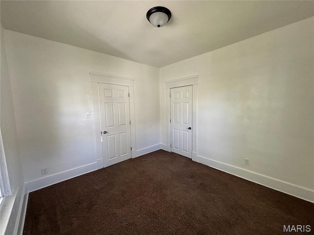 1014 E Broadway, Centralia, IL 62801 - unfurnished room with baseboards and dark colored carpet