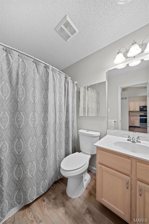 1149 Silo Bnd Unit 341A, Wentzville, MO 63385 - full bath featuring wood finished floors, vanity, and a textured ceiling