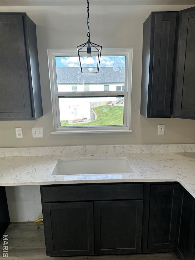 204 Pacific Ave, Union, MO 63084 - kitchen with dark cabinets, wood finished floors, light stone counters, and hanging light fixtures
