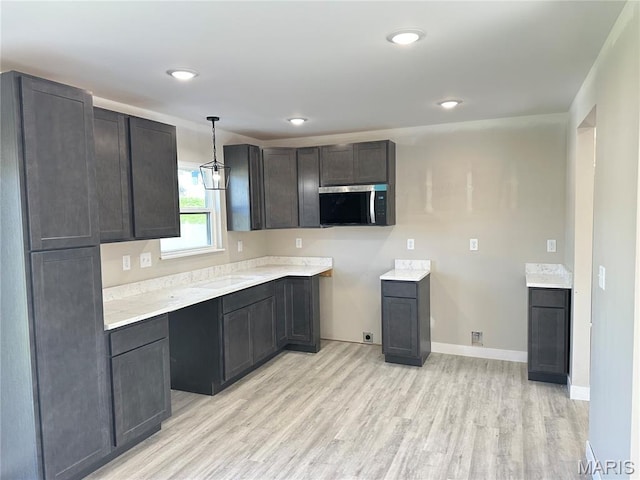 204 Pacific Ave, Union, MO 63084 - kitchen with stainless steel microwave, light wood finished floors, baseboards, decorative light fixtures, and recessed lighting