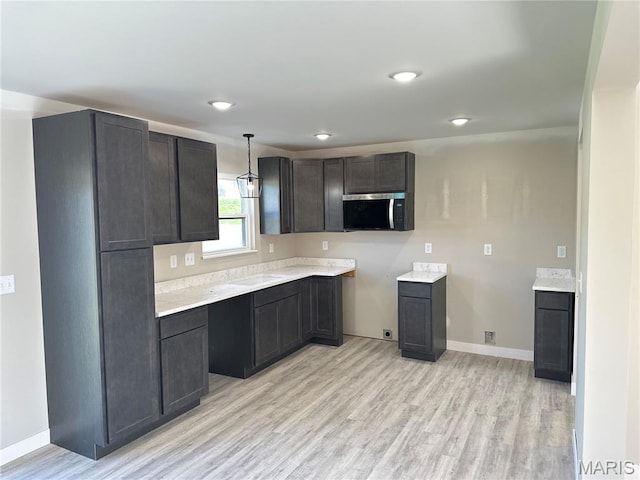 204 Pacific Ave, Union, MO 63084 - kitchen featuring stainless steel microwave, light wood-style floors, baseboards, and light countertops