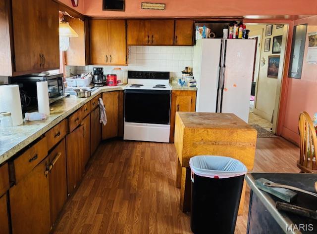 206 1st St, Steelville, MO 65565 - kitchen with white appliances, brown cabinetry, dark wood-type flooring, and decorative backsplash