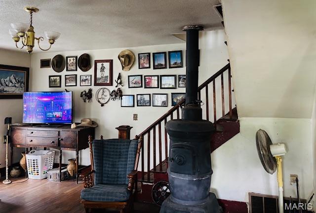206 1st St, Steelville, MO 65565 - stairway with wood finished floors, a chandelier, and a textured ceiling