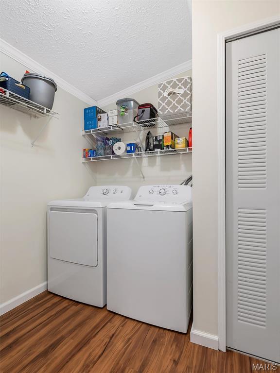 3870 Wilkinson Rd, De Soto, MO 63020 - laundry area featuring separate washer and dryer, ornamental molding, wood finished floors, and a textured ceiling