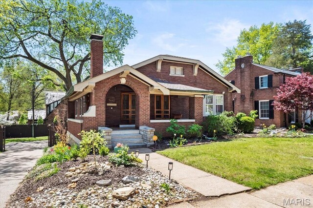 7440 Kingsbury Blvd, Saint Louis, MO 63130 - view of front of house with brick siding, a chimney, and covered porch