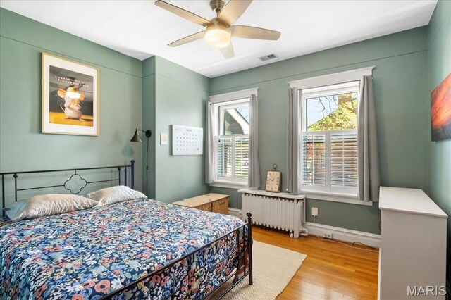 7440 Kingsbury Blvd, Saint Louis, MO 63130 - bedroom with radiator, light wood finished floors, a ceiling fan, and baseboards
