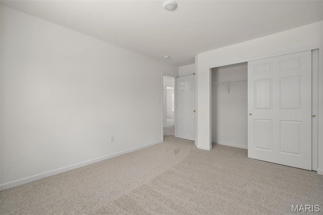unfurnished bedroom featuring carpet flooring, baseboards, and a closet