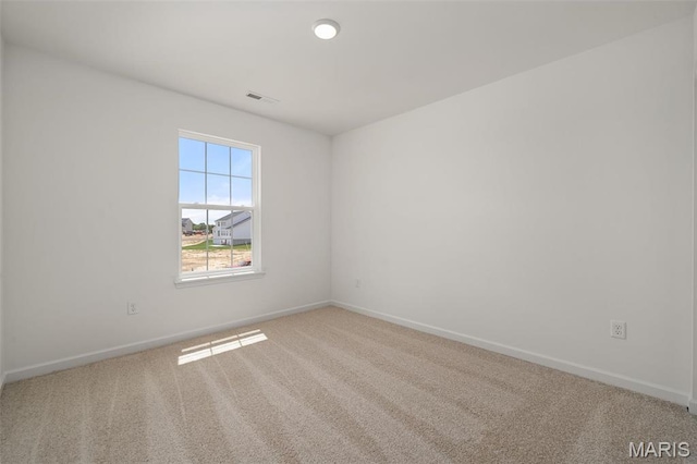 empty room featuring carpet flooring and baseboards