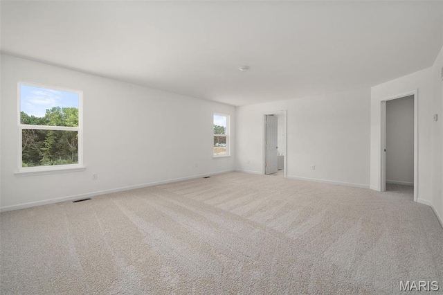 carpeted empty room featuring baseboards