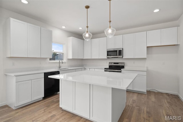 kitchen featuring appliances with stainless steel finishes, a center island, light wood-style floors, recessed lighting, and white cabinets