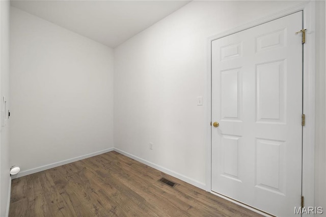 empty room featuring wood finished floors and baseboards