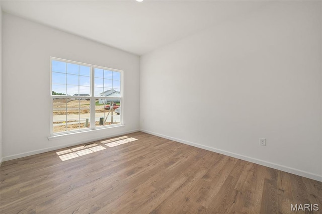 empty room with baseboards and wood finished floors