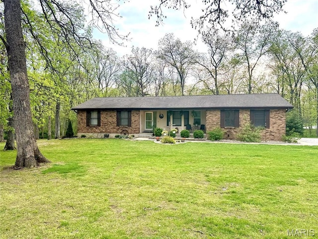 ranch-style home featuring covered porch, a front yard, and brick siding
