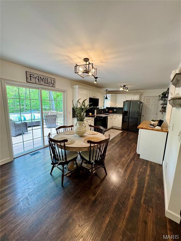 dining space featuring dark wood-style flooring and baseboards