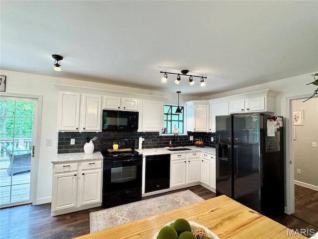 kitchen featuring black appliances, a sink, white cabinets, tasteful backsplash, and dark wood-style floors