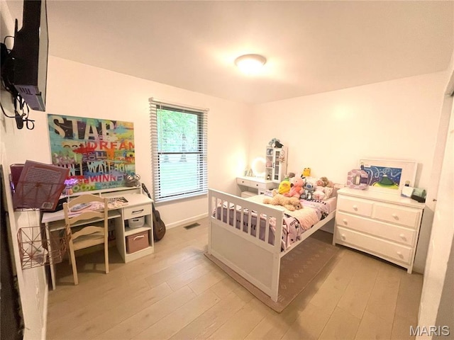 bedroom with light wood-style floors and baseboards