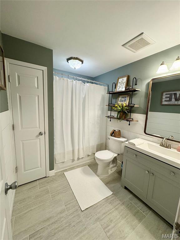full bathroom with toilet and vanity