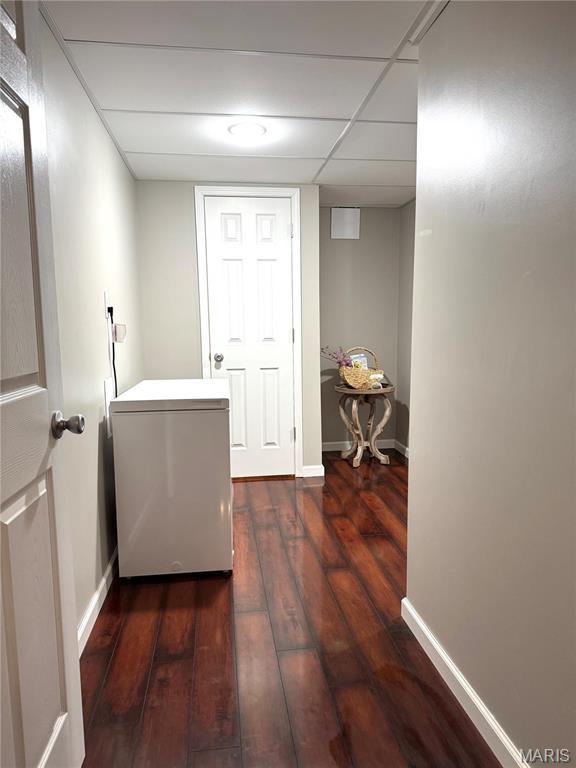 clothes washing area with hardwood / wood-style floors and baseboards