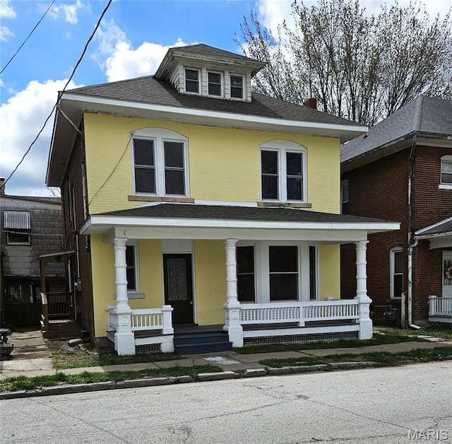 american foursquare style home featuring covered porch