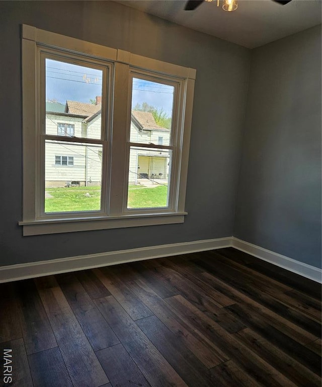 empty room featuring dark wood-style flooring and baseboards