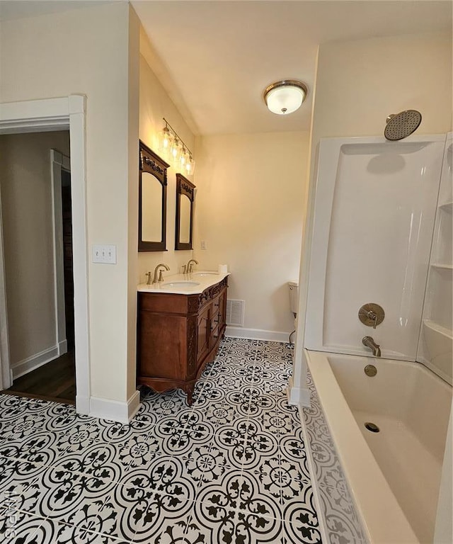full bathroom featuring baseboards, double vanity, tile patterned floors, and washtub / shower combination