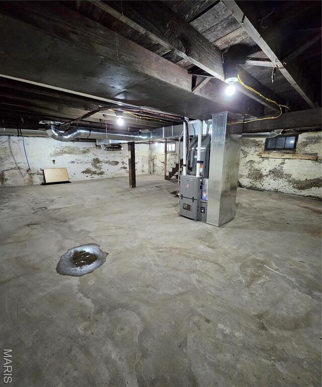 unfinished below grade area featuring heating unit and stairway