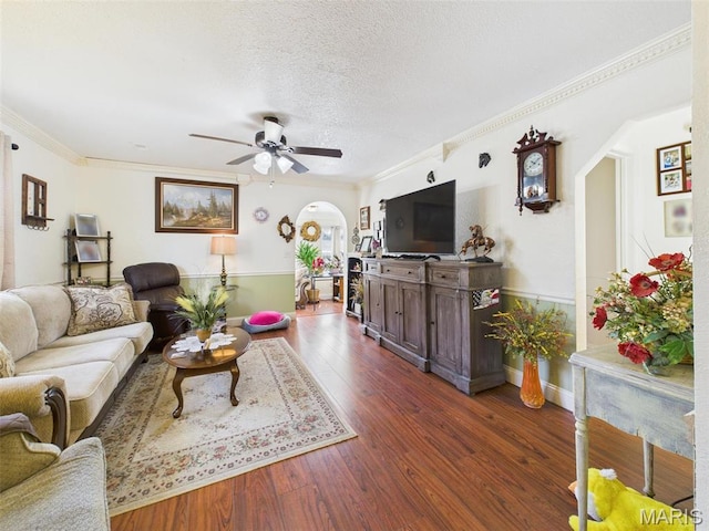 462 Harrison St, Lebanon, MO 65536 - living room with arched walkways, ceiling fan, wainscoting, dark wood-type flooring, and crown molding