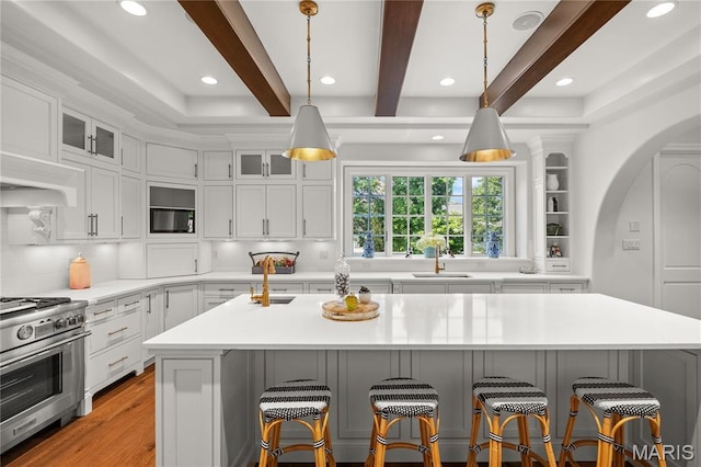42 Rolling Rock Ct, Saint Louis, MO 63124 - kitchen featuring stainless steel range, a breakfast bar area, built in microwave, light countertops, and a sink
