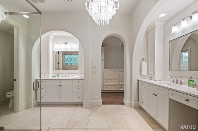 42 Rolling Rock Ct, Saint Louis, MO 63124 - full bathroom with two vanities, toilet, tile patterned flooring, and a chandelier
