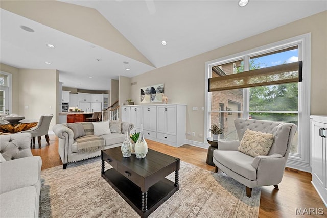 living room with lofted ceiling, healthy amount of natural light, light wood-style floors, and recessed lighting