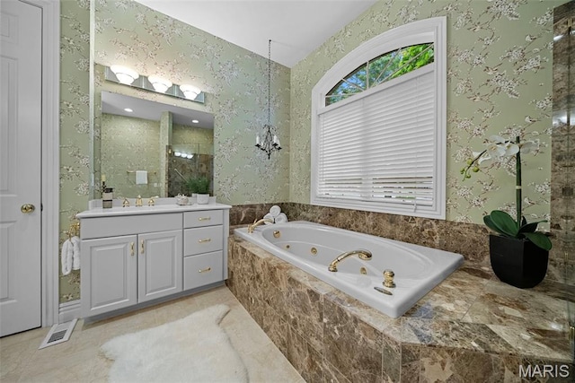 bathroom with plenty of natural light, wallpapered walls, a tub with jets, vanity, and a tile shower