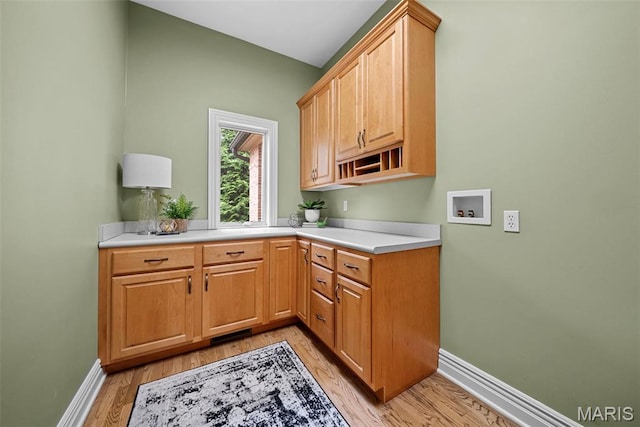 kitchen with baseboards, light wood-type flooring, and light countertops