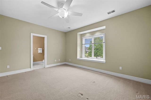 unfurnished room featuring light carpet, a ceiling fan, and baseboards