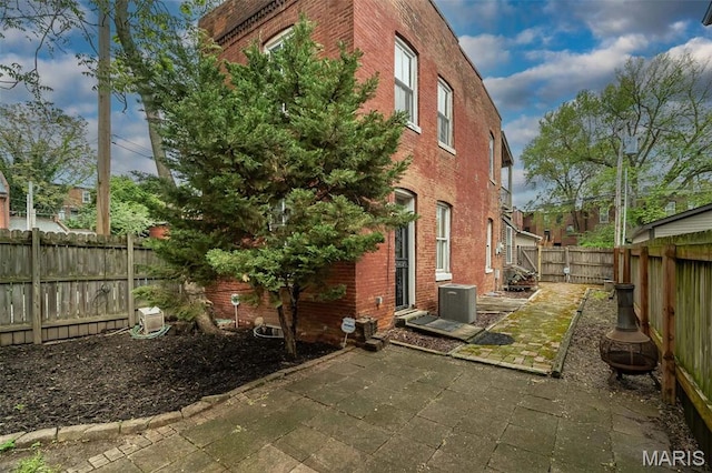 1003 Allen Ave, Saint Louis, MO 63104 - view of property exterior with brick siding, a patio, a fenced backyard, and cooling unit
