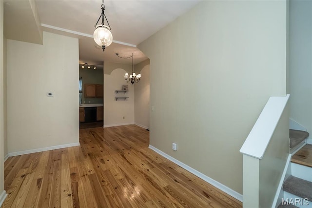 1003 Allen Ave, Saint Louis, MO 63104 - unfurnished dining area featuring a chandelier, light wood-type flooring, and baseboards