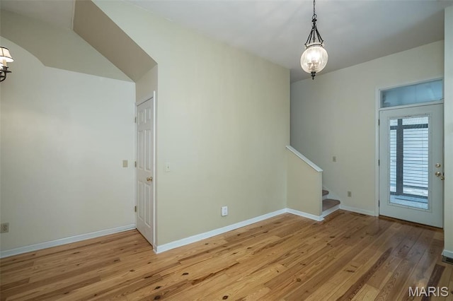 1003 Allen Ave, Saint Louis, MO 63104 - spare room featuring a chandelier, light wood-style floors, stairway, and baseboards