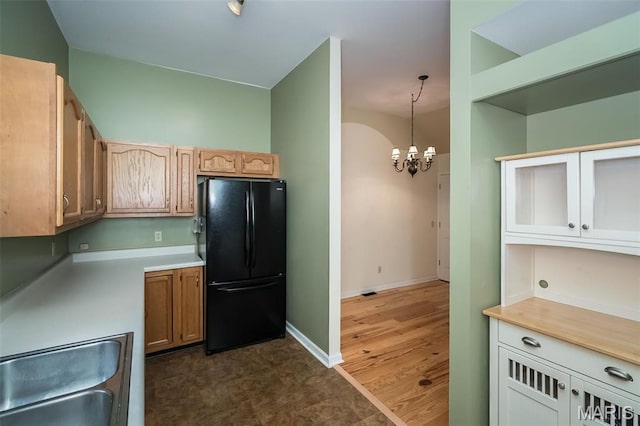 1003 Allen Ave, Saint Louis, MO 63104 - kitchen with freestanding refrigerator, a chandelier, a sink, light countertops, and baseboards